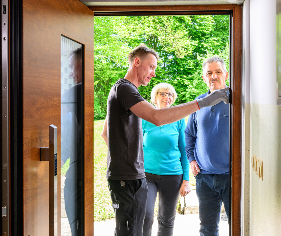 Montažer pojasnjuje lastnikoma uporabo novih vhodnih vrat